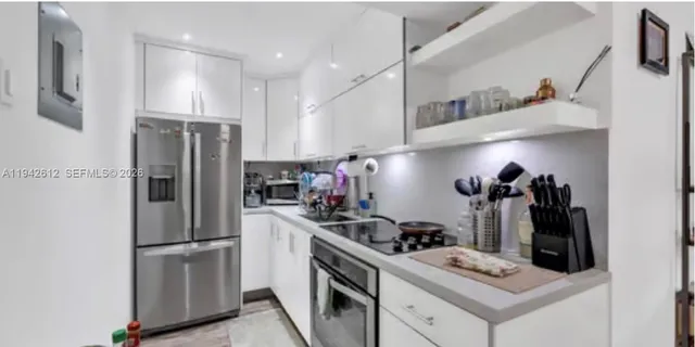a kitchen with a refrigerator and a stove top oven