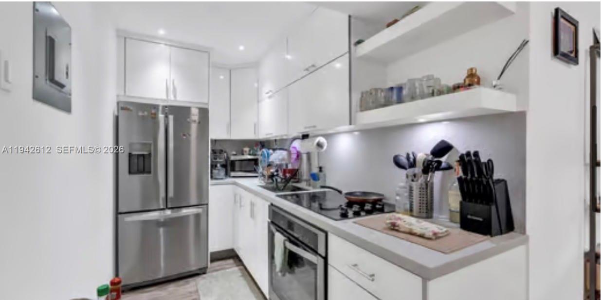 4841 Northwest 7th Street, Unit 3034 Miami, FL 33126 - Photo 13 of 35 a kitchen with a refrigerator and a stove top oven