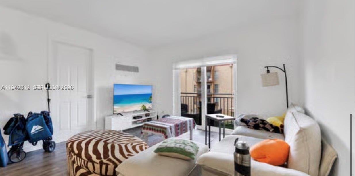 4841 Northwest 7th Street, Unit 3034 Miami, FL 33126 - Photo 15 of 35 a bedroom with furniture and a wooden floor