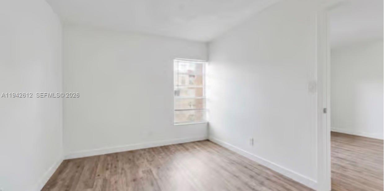 4841 Northwest 7th Street, Unit 3034 Miami, FL 33126 - Photo 22 of 35 an empty room with wooden floor and window
