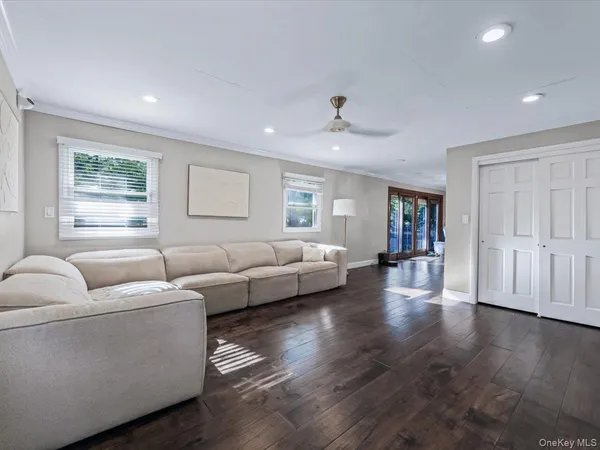 a living room with couches and a view of kitchen