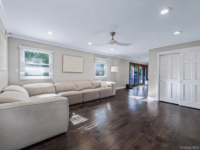 a living room with couches and a view of kitchen