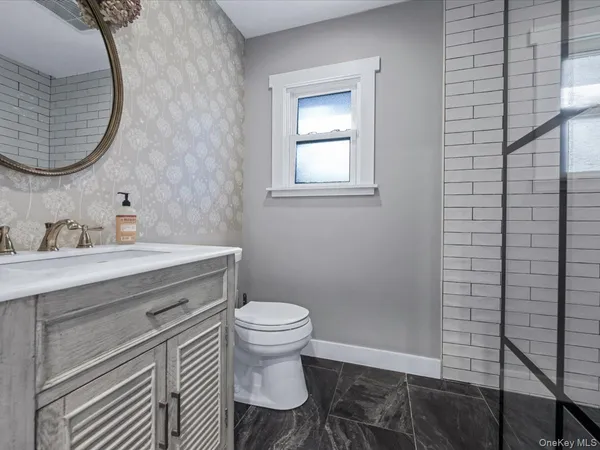 a bathroom with a sink toilet and a mirror