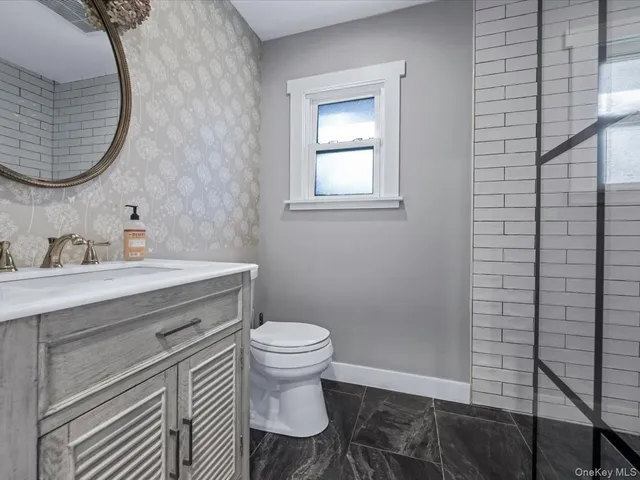 a bathroom with a sink toilet and a mirror