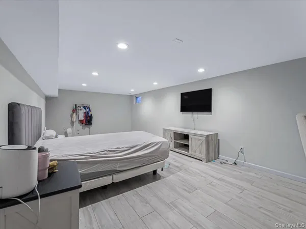 a spacious bedroom with a bed and a flat screen tv