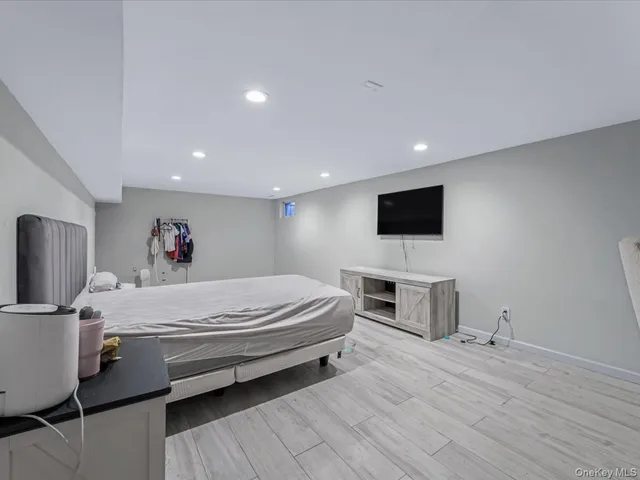 a spacious bedroom with a bed and a flat screen tv