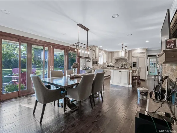 a dining room with furniture a chandelier and wooden floor