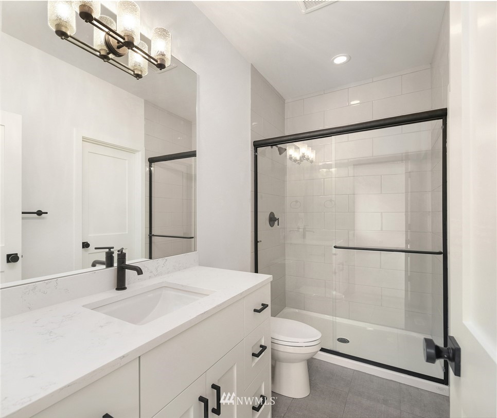 23521 7th Avenue Southeast Bothell, WA 98021 - Photo 21 of 27 a bathroom with a sink toilet a mirror and shower