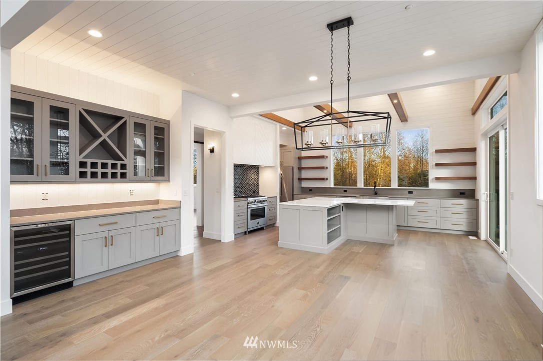 23521 7th Avenue Southeast Bothell, WA 98021 - Photo 25 of 27 a kitchen with stainless steel appliances kitchen island granite countertop a stove a sink and white cabinets with wooden floor