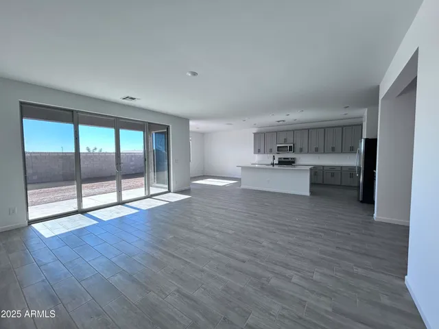 a view of a kitchen with wooden floor and a window