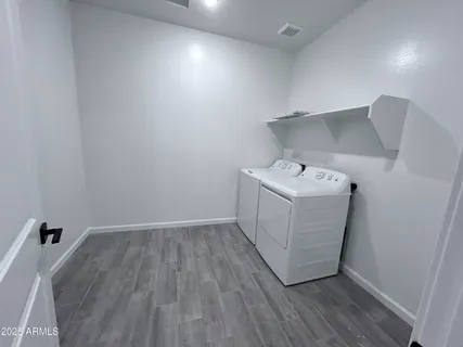 a utility room with wooden floor washer and dryer