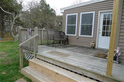 35 South Sunken Meadow Road Eastham, MA 02642 - Photo 20 of 22 a view of a house with a wooden deck and a yard with wooden fence