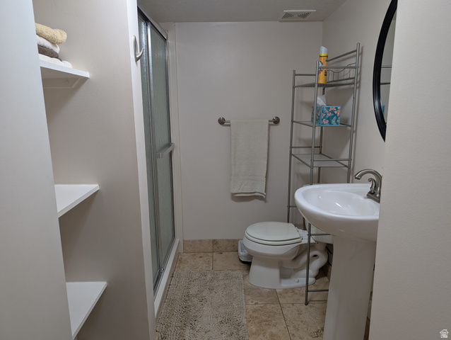 1411 Millbrook Way Bountiful, UT 84010 - Photo 31 of 36 Bathroom featuring a pedestal sink with a brushed nickel faucet, a toilet, and a shower with a sliding glass door