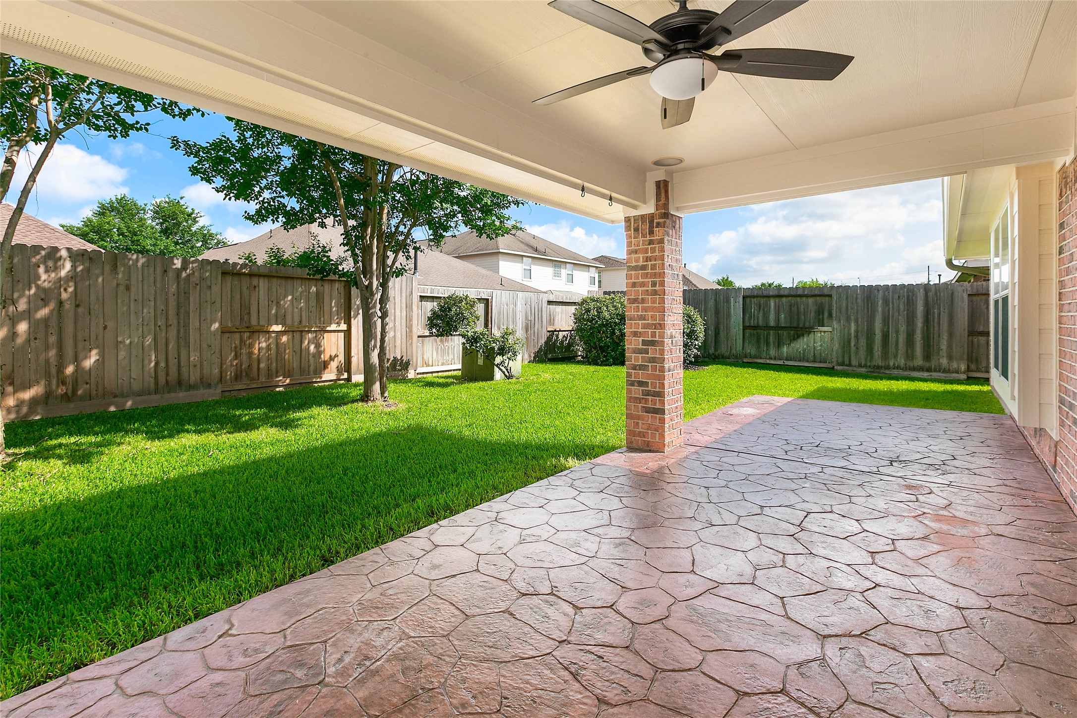 30411 Deleon Fields Drive Spring, TX 77386 - Photo 23 of 24 Expansive covered patio with a stylish stamped concrete surface, perfect for outdoor enjoyment.