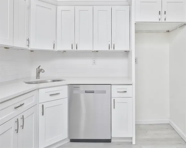 a kitchen with white cabinets and white appliances