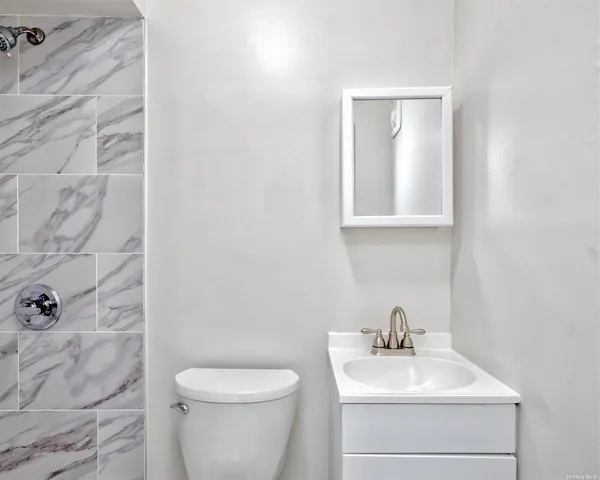 a bathroom with a sink mirror and toilet