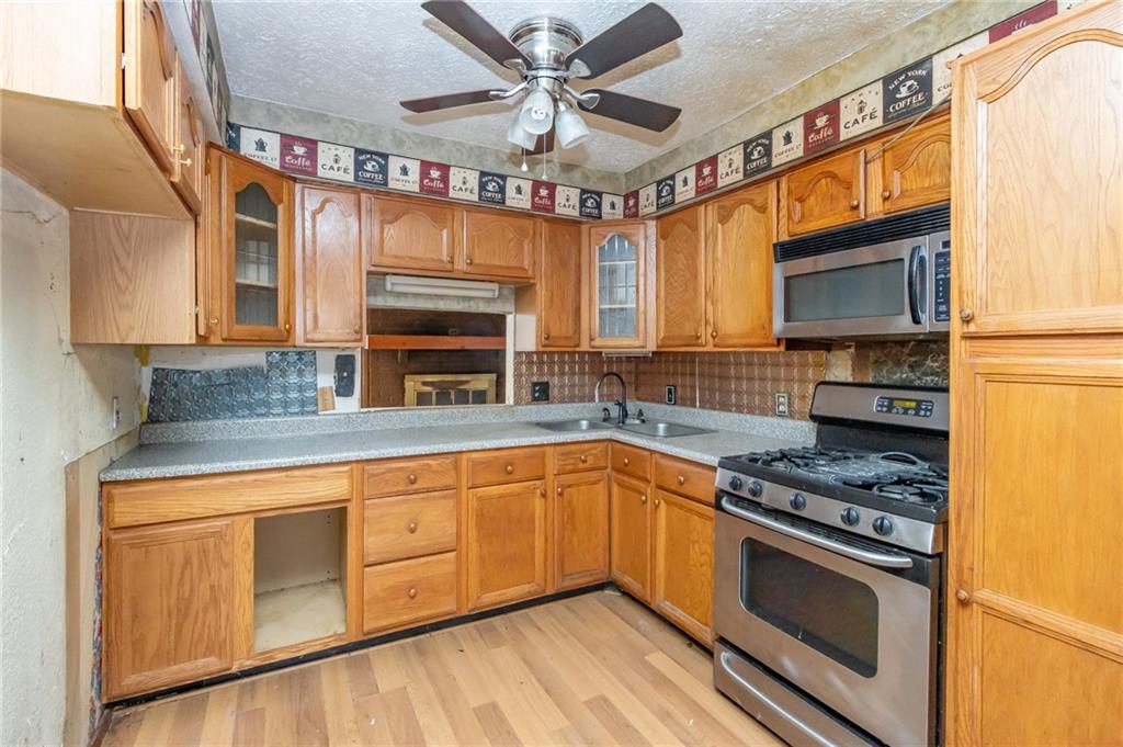284 Myoma Road Mars, PA 16046 - Photo 15 of 33 a kitchen with granite countertop a stove a sink and a microwave