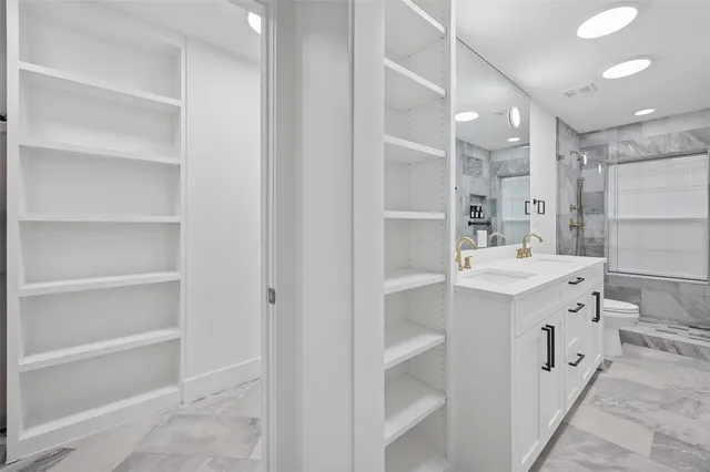 a bathroom with a sink vanity and shower