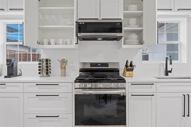 a kitchen with white cabinets and appliances