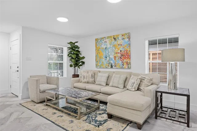 a living room with furniture a couch and a potted plant