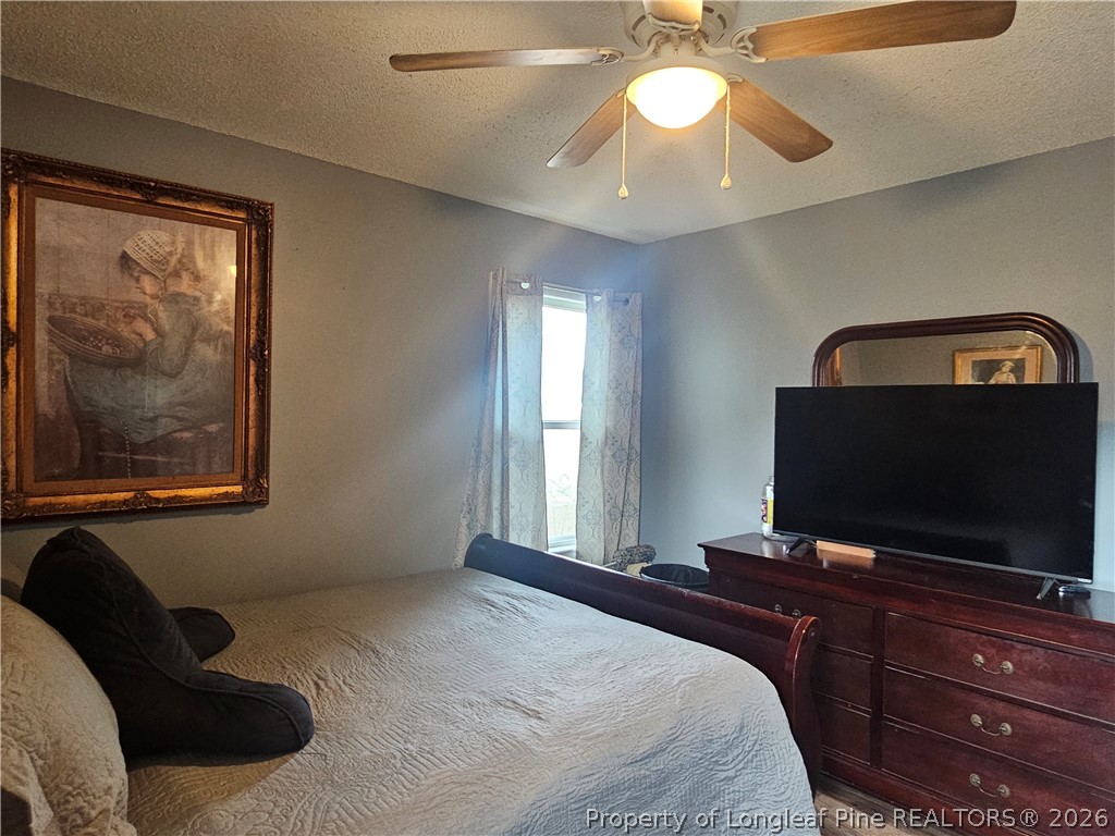 4547 Legion Road Hope Mills, NC 28348 - Photo 19 of 28 a bedroom with a bed and a flat screen tv