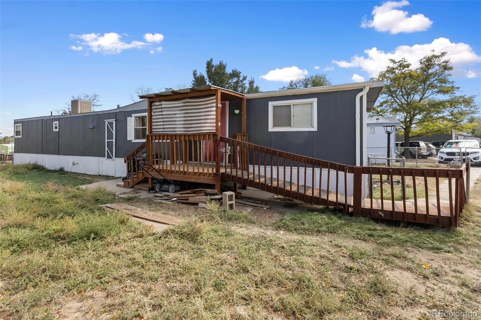 600 Raintree Boulevard, Unit 98 Canon City, CO 81212 - Photo 24 of 25 a view of a house with a wooden deck and a yard