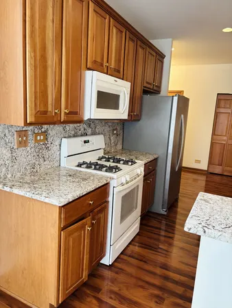 a kitchen with stainless steel appliances granite countertop a stove a sink and a microwave
