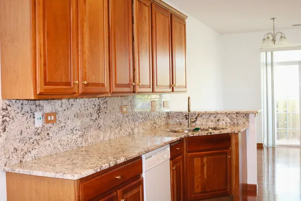 a sink with granite countertop cabinets and a wooden floor