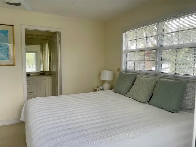 a large bed sitting in a bedroom next to a window