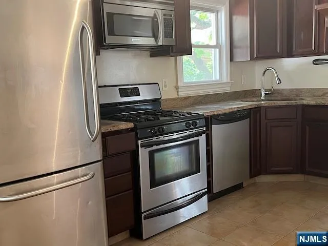 a kitchen with stainless steel appliances granite countertop a stove microwave and sink
