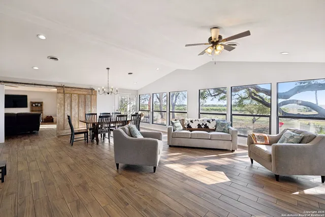 a living room with furniture and large windows