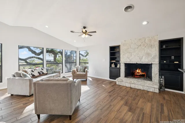 a view of a dining room and livingroom with furniture wooden floor a chandelier