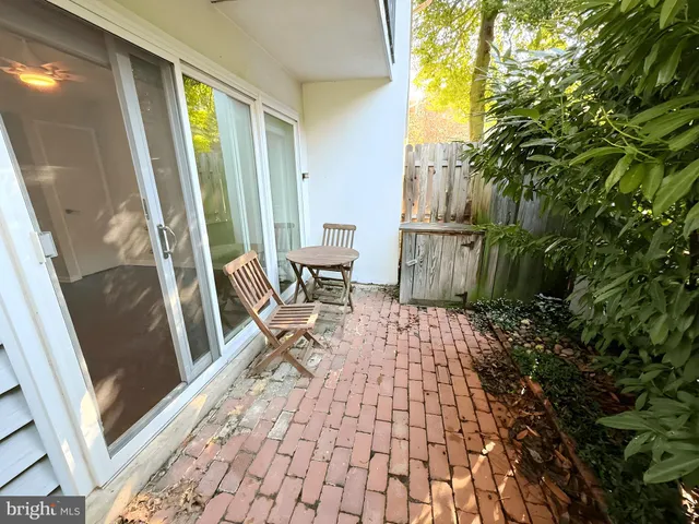 a view of a porch with chairs and floor to ceiling window