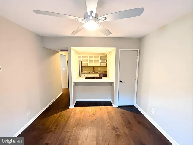 a view of a room with wooden floor and a ceiling fan
