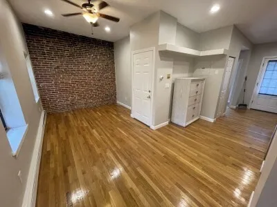 en empty room with wooden floor and ceiling fan