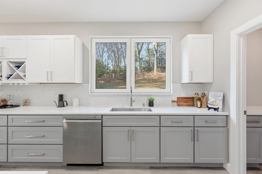 287 Whitney Avenue Holyoke, MA 01040 - Photo 13 of 40 a kitchen with white cabinets and sink