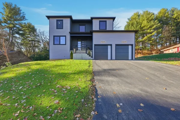 a front view of a house with a yard and garage