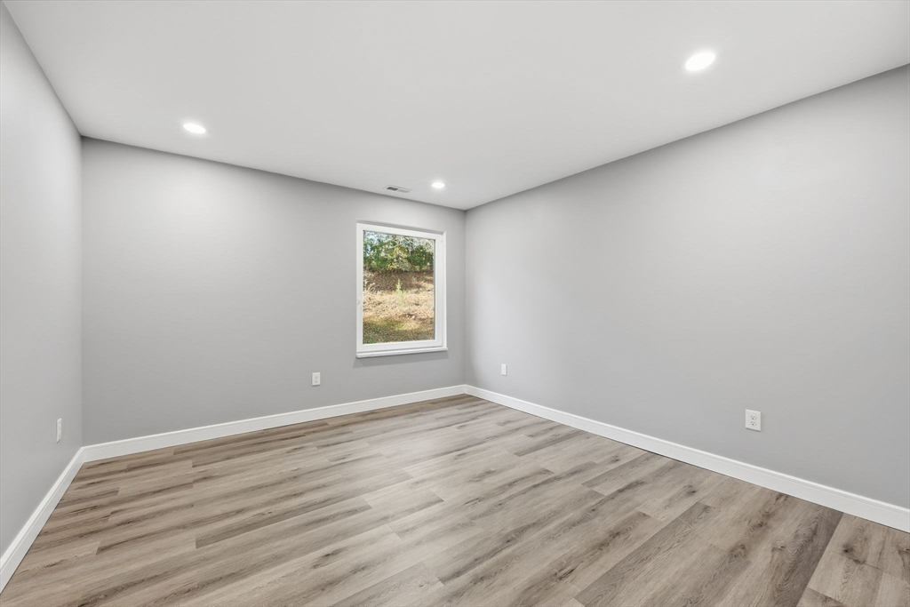 287 Whitney Avenue Holyoke, MA 01040 - Photo 30 of 40 an empty room with wooden floor and windows