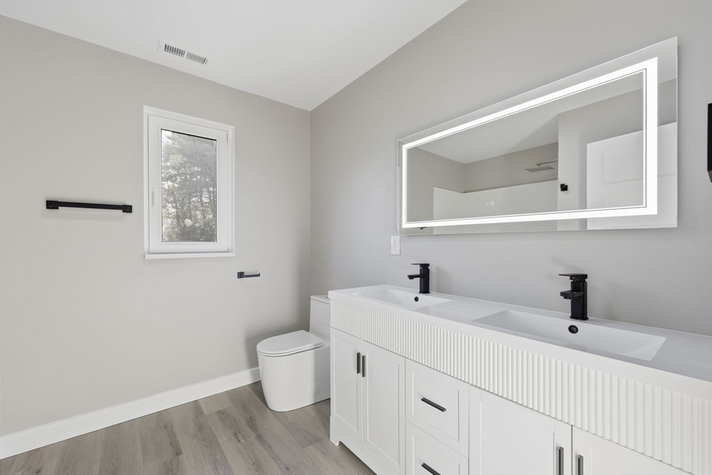 287 Whitney Avenue Holyoke, MA 01040 - Photo 33 of 40 a bathroom with a toilet sink and mirror