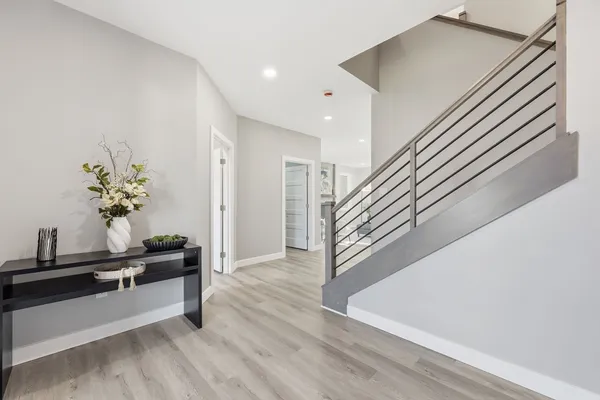 a view of a hallway with wooden floor and stairs