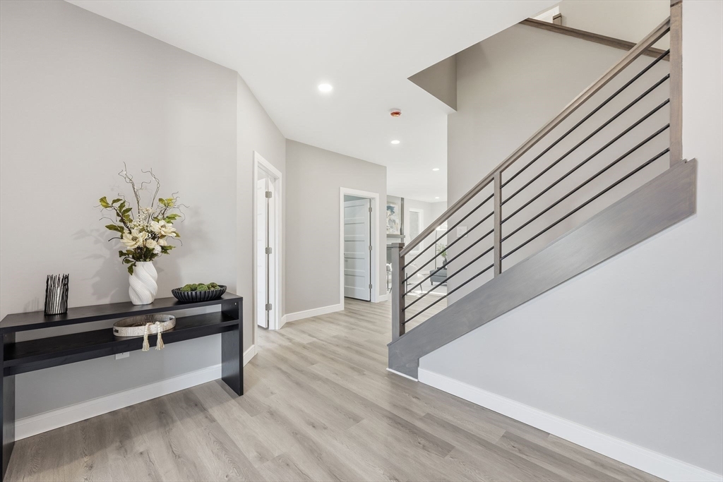 287 Whitney Avenue Holyoke, MA 01040 - Photo 6 of 40 a view of a hallway with wooden floor and stairs