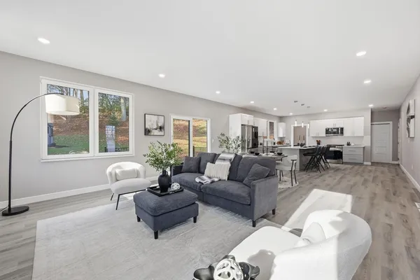 a living room with furniture a fireplace wooden floor and a fireplace