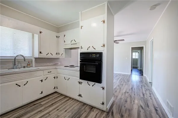 a kitchen with cabinets wooden floor and a fireplace