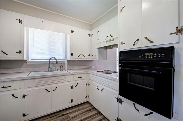 a kitchen with cabinets stove and sink