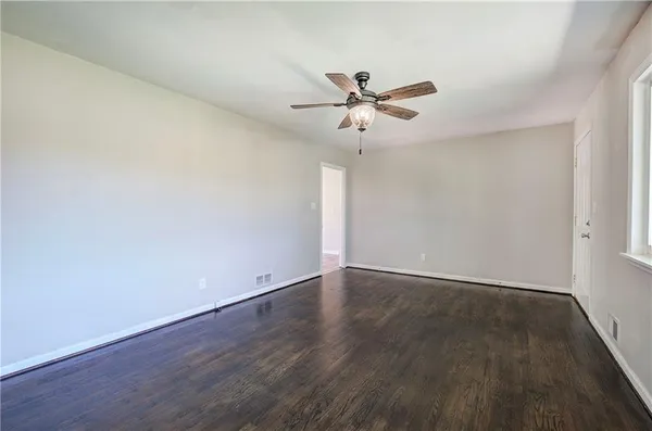 a view of an empty room with wooden floor