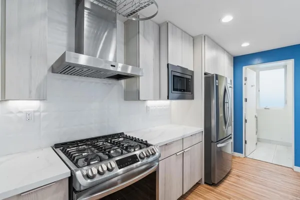 a kitchen with stainless steel appliances granite countertop a stove and a refrigerator