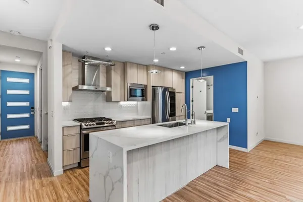 a kitchen with stainless steel appliances granite countertop a sink stove and refrigerator