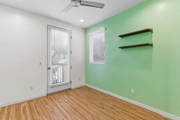 an empty room with wooden floor and windows