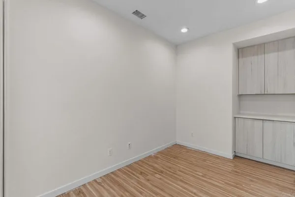 a view of an empty room with wooden floor