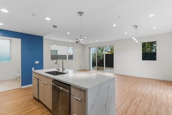 a kitchen with a sink and wooden floor